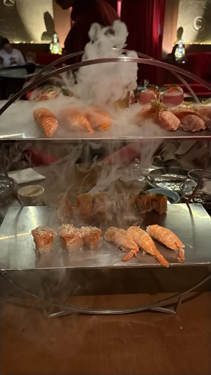 Torre do omakase do Oue Sushi Bar, na Berrini, com sushi e sashimi sob fumaça